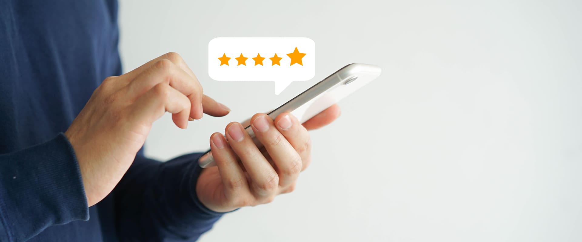 Person hält ein Smartphone und hinterlässt eine Fünf-Sterne-Bewertung