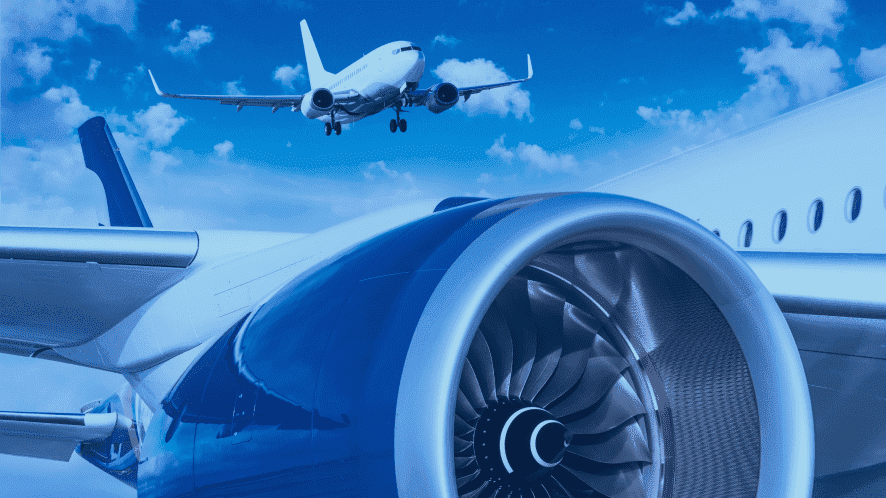 Detailaufnahme eines Flugzeugtriebwerks mit einem startenden Flugzeug im Hintergrund